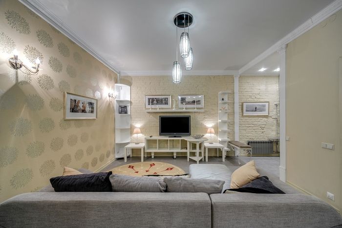 Living room with subtle cream-on-cream floral wallpaper and a grey sectional sofa