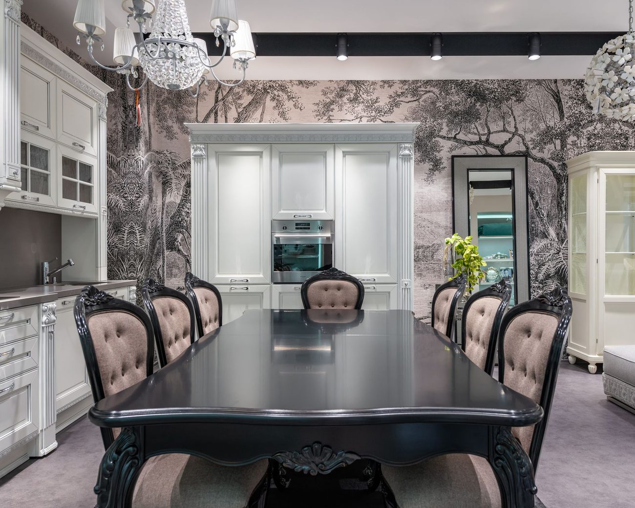 Elegant dining room with black-and-white toile forest mural wallpaper, a dark table and upholstered chairs